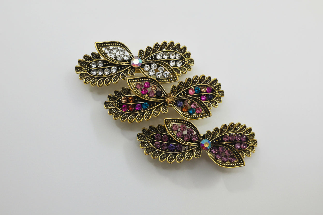 Butterfly-shaped jewelry pieces with gemstones on a white background